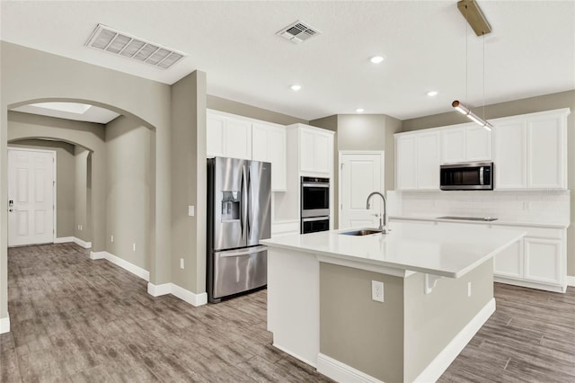 kitchen featuring light wood-style floors, visible vents, appliances with stainless steel finishes, and a sink