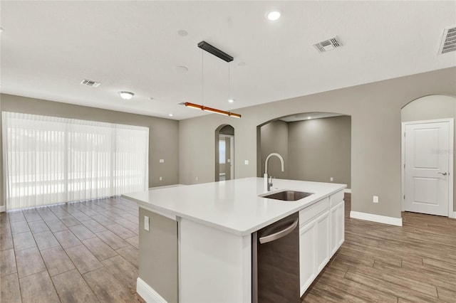 kitchen with stainless steel dishwasher, light wood-style floors, visible vents, and a sink