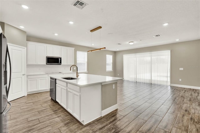 kitchen with visible vents, a sink, open floor plan, stainless steel appliances, and wood tiled floor