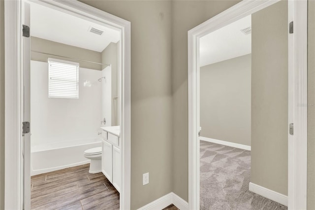 bathroom featuring visible vents, baseboards, toilet, vanity, and  shower combination