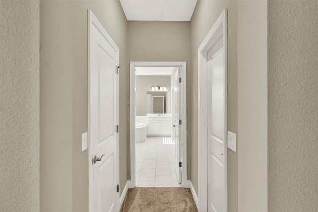 hall with tile patterned flooring and a textured wall