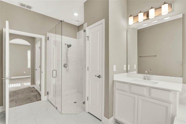 full bath with vanity, baseboards, visible vents, and a stall shower