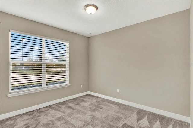 unfurnished room with baseboards and carpet floors