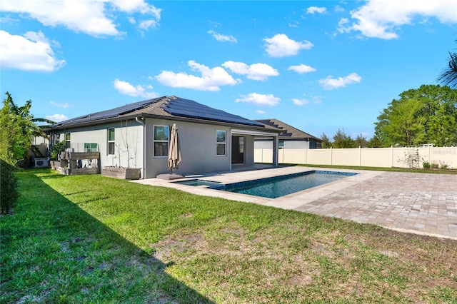 back of property featuring stucco siding, a patio, a lawn, and a fenced backyard