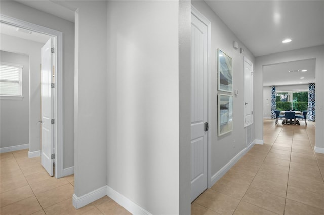 hall featuring recessed lighting, light tile patterned flooring, and baseboards