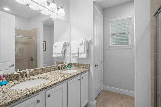 bathroom featuring double vanity, tile patterned flooring, a sink, and a shower stall