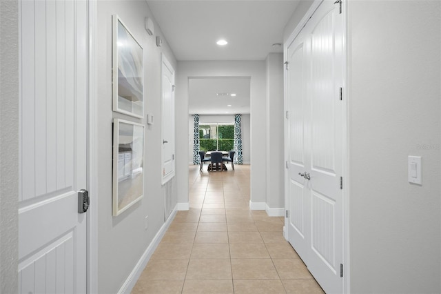 hallway with recessed lighting, baseboards, and light tile patterned flooring