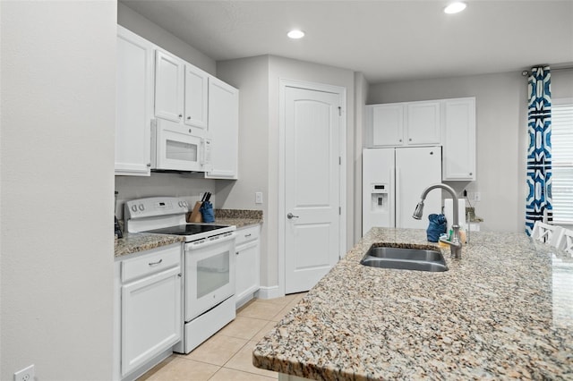 kitchen featuring white appliances, light tile patterned flooring, a sink, and white cabinets