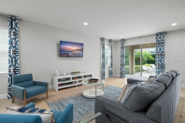 living room featuring baseboards, a textured ceiling, tile patterned floors, and recessed lighting