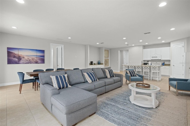living room with light tile patterned floors, baseboards, and recessed lighting