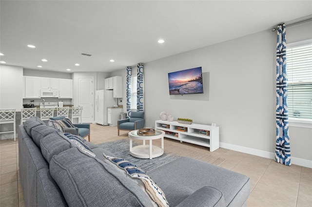 living area featuring light tile patterned floors, baseboards, and recessed lighting