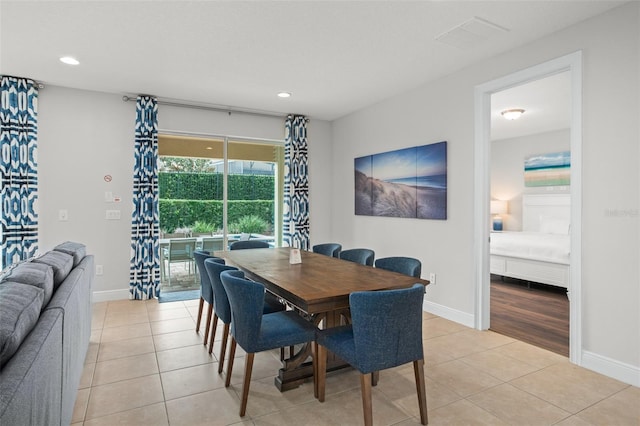 dining space featuring light tile patterned floors, visible vents, and baseboards