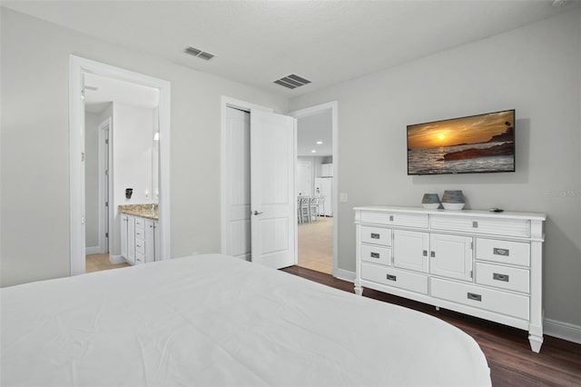 bedroom featuring baseboards, visible vents, and dark wood-style flooring