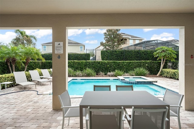 view of pool featuring a pool with connected hot tub, a patio, and fence