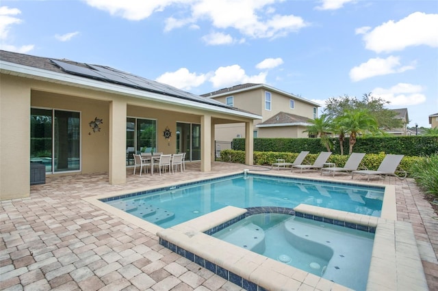 view of pool with a pool with connected hot tub, a patio, and outdoor dining area