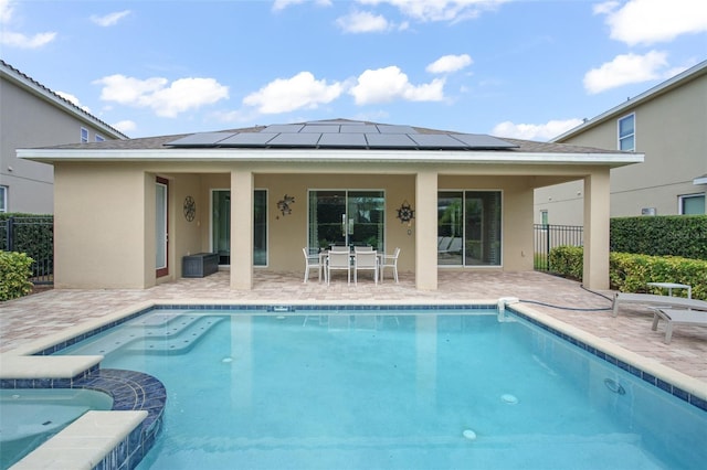 view of pool featuring a pool with connected hot tub, a patio, outdoor dining area, and fence