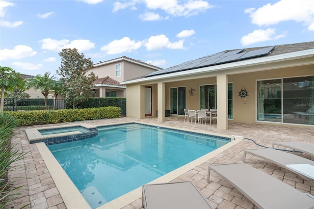 view of swimming pool featuring a pool with connected hot tub, outdoor dining area, a patio area, and fence