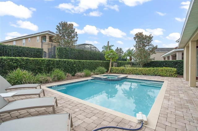 view of pool with a patio area, fence, and a pool with connected hot tub