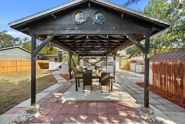 view of patio featuring a gazebo, outdoor dining area, and a fenced backyard