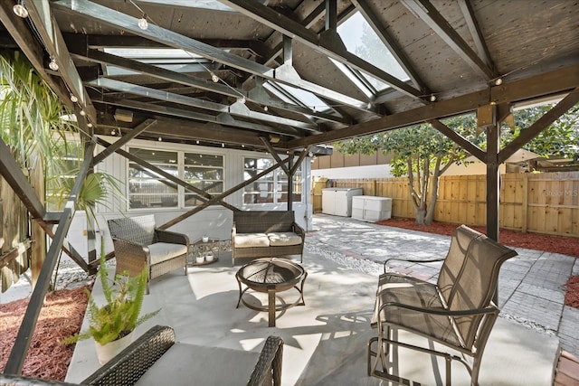 view of patio / terrace with a fire pit, washer / dryer, and fence