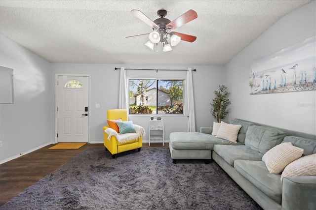 living room with baseboards, a textured ceiling, ceiling fan, and wood finished floors