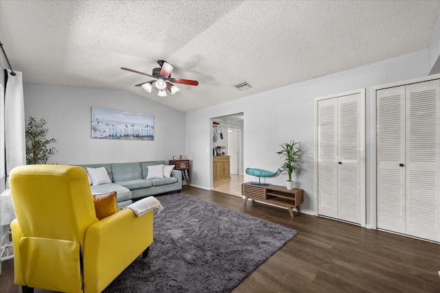 living room with visible vents, a ceiling fan, a textured ceiling, wood finished floors, and vaulted ceiling