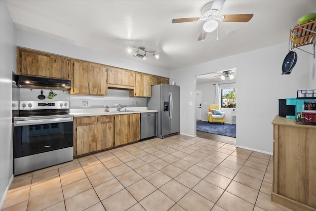 kitchen featuring ceiling fan, under cabinet range hood, light countertops, stainless steel appliances, and a sink