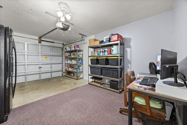 garage with a garage door opener and black refrigerator with ice dispenser