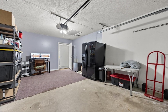 garage featuring a garage door opener and black refrigerator with ice dispenser