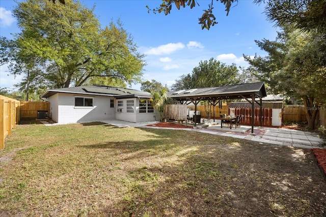 view of yard featuring a gazebo, a patio, a fenced backyard, and a sunroom