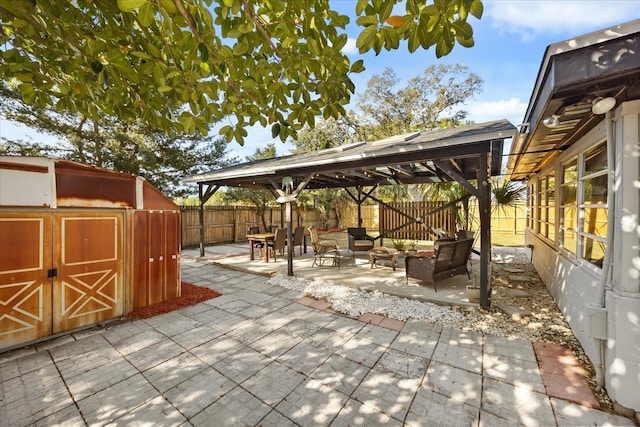 view of patio featuring a gazebo, a fenced backyard, an outbuilding, and a shed