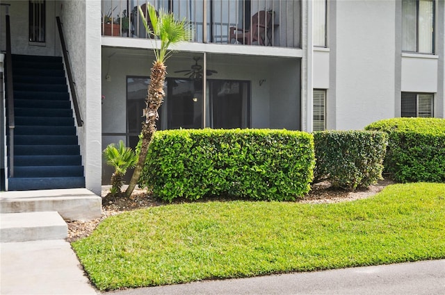 property entrance with a yard, a balcony, and stucco siding