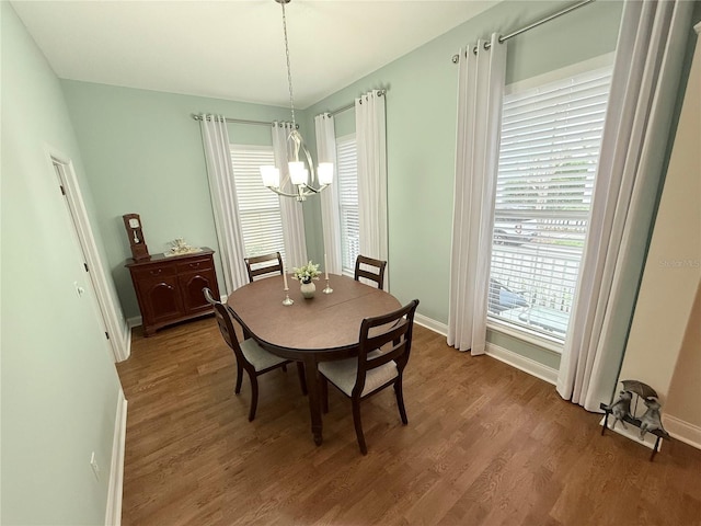 dining area featuring baseboards, an inviting chandelier, and light wood-style flooring