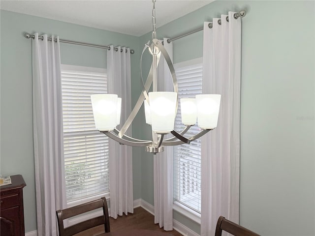 room details featuring a notable chandelier, baseboards, and wood finished floors