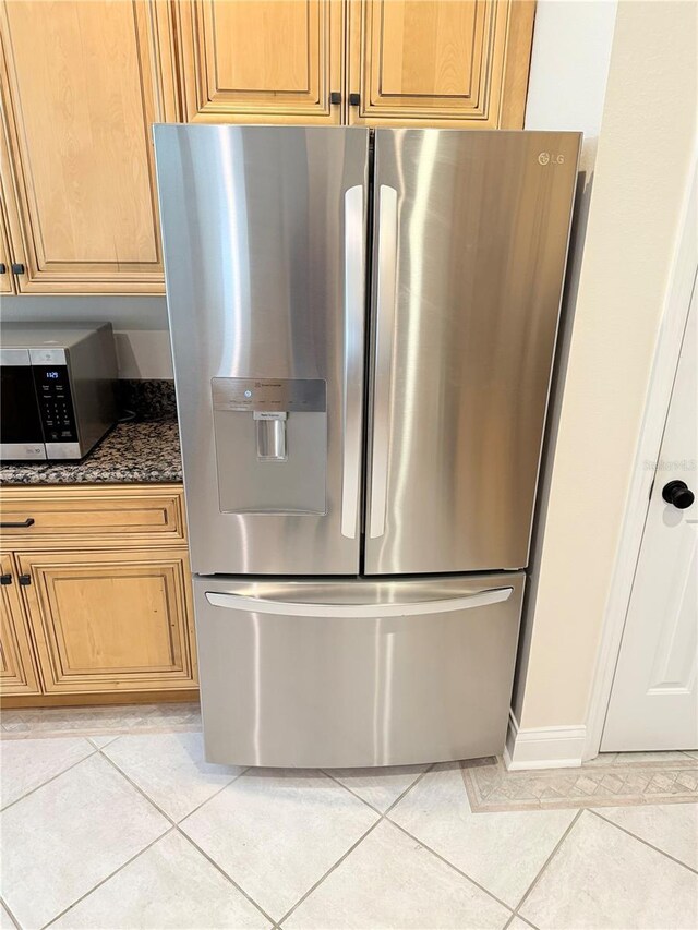 room details with dark stone countertops and appliances with stainless steel finishes