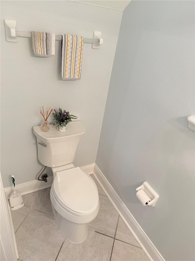 bathroom featuring tile patterned flooring, toilet, and baseboards