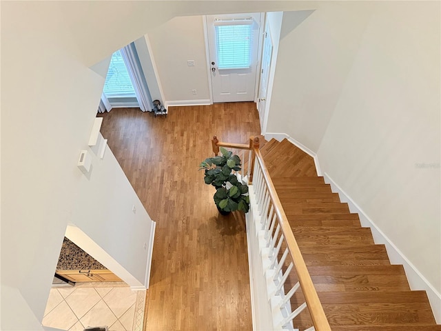 entryway featuring stairway, wood finished floors, baseboards, and a healthy amount of sunlight