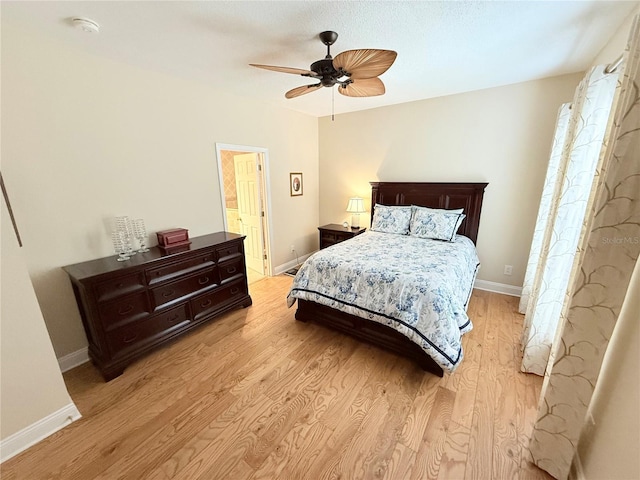 bedroom with a ceiling fan, baseboards, and light wood finished floors