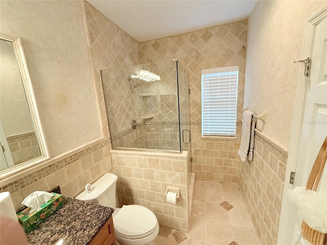 bathroom featuring toilet, tile walls, tile patterned flooring, tiled shower, and vanity