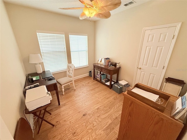 office space with visible vents, ceiling fan, baseboards, and light wood-style floors