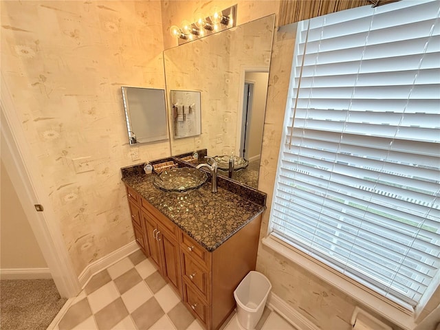 bathroom with wallpapered walls, tile patterned floors, vanity, and baseboards