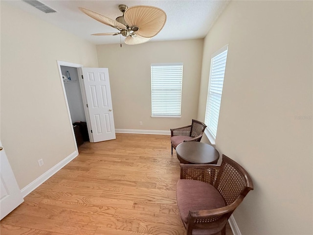 sitting room featuring visible vents, baseboards, and light wood-style floors