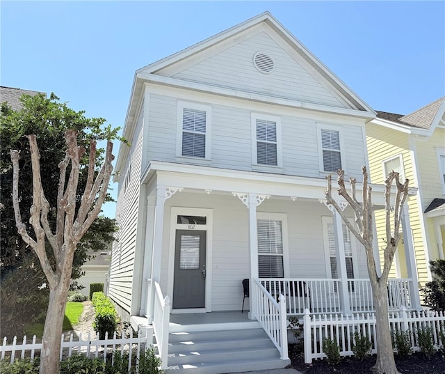 greek revival house with fence and covered porch