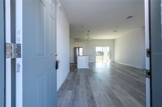 entrance foyer featuring light wood-style flooring, visible vents, and baseboards