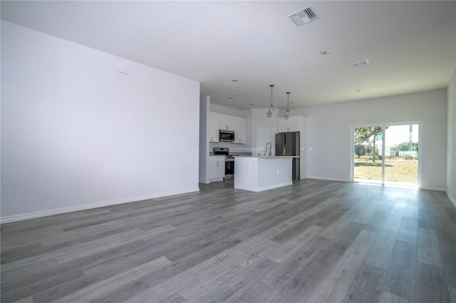 unfurnished living room featuring light wood-type flooring, baseboards, visible vents, and a sink