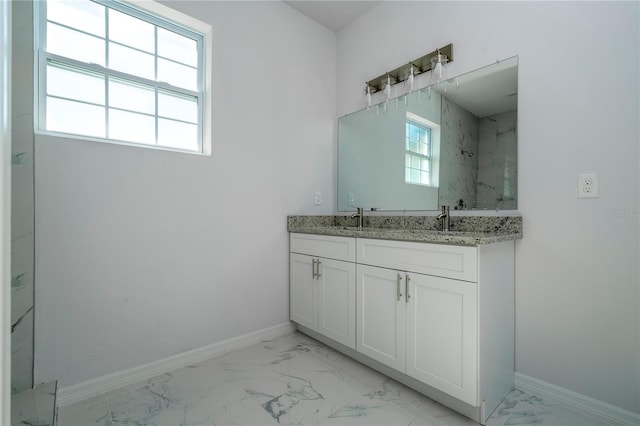 bathroom featuring marble finish floor, plenty of natural light, and baseboards