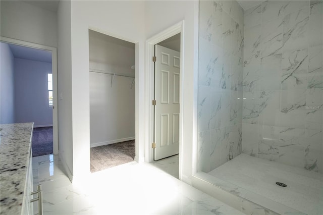 bathroom featuring marble finish floor and a stall shower