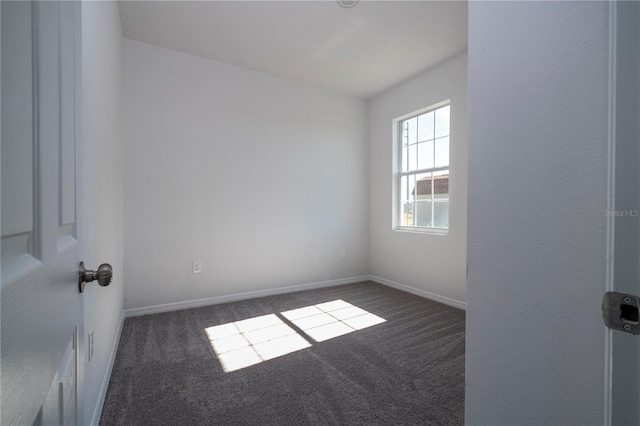 carpeted spare room featuring baseboards