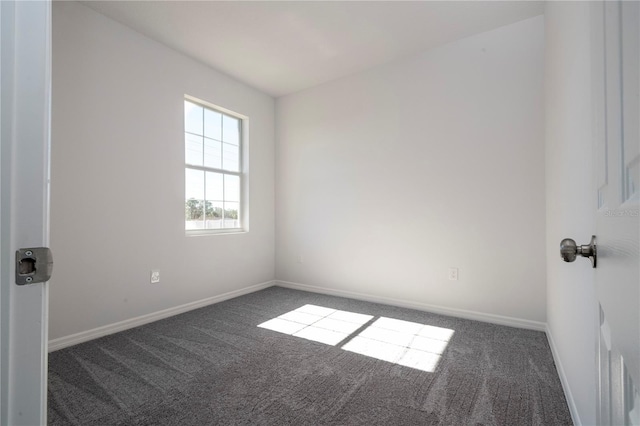 carpeted spare room featuring baseboards