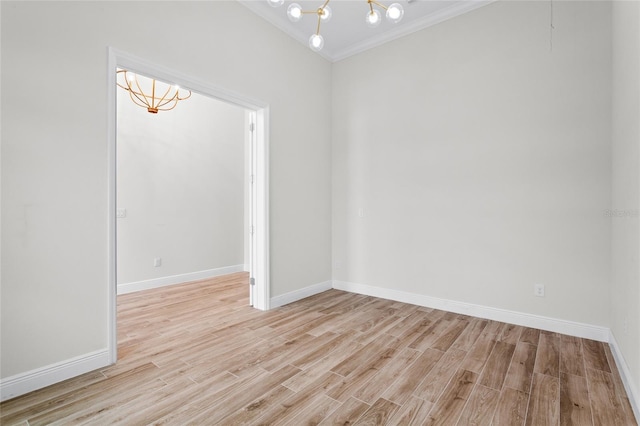 empty room featuring light wood-type flooring, baseboards, and a notable chandelier